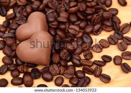 Chocolates in the form of heart on the background of coffee beans on Food and Drink
