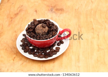 Full coffee cup and saucer of coffee beans on the wooden table on Food and Drink
