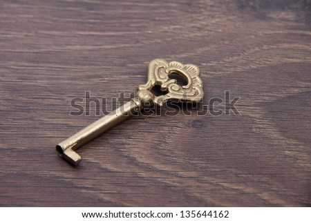 Beautiful antique metal key on dark wooden background/Vintage keys on a beautiful wooden background with a pattern