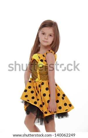 Positive emotional little girl in a beautiful ball gown on white background on Holiday