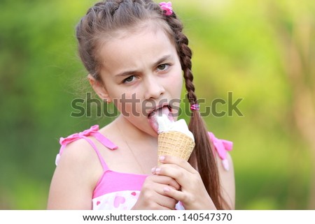 Happy child eating ice-cream outdoors in park