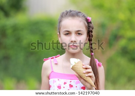 Happy children eating ice-cream outdoors in park