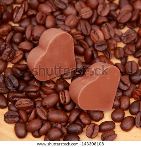 Background of coffee beans/Delicious chocolate heart symbol candies and dark brown coffee beans