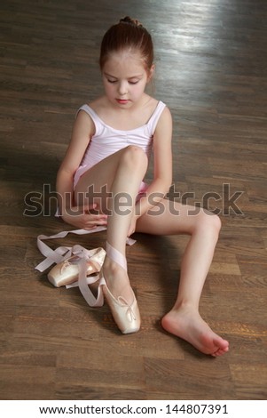 Lovely little ballerina wearing tutu and posing on camera