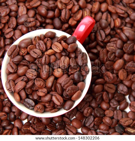 Background from coffee beans/Top view on coffee beans in ceramic red coffee cup