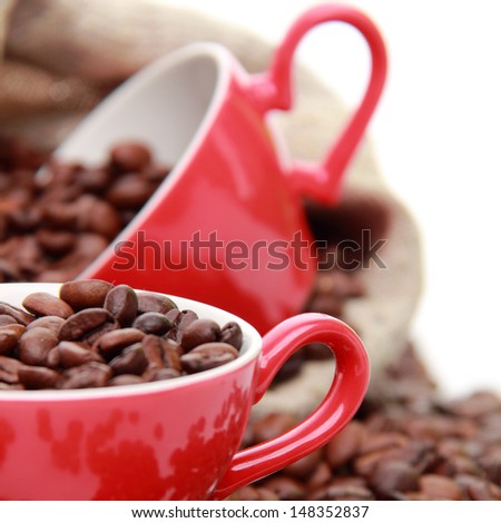 Coffee beans in ceramic red coffee cup with heart symbol