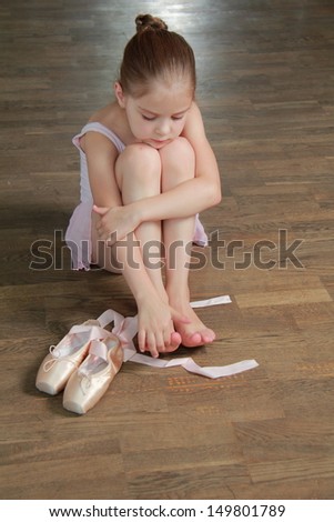Lovely ballerina puts on pointe in ballet class at the old wooden dance floor