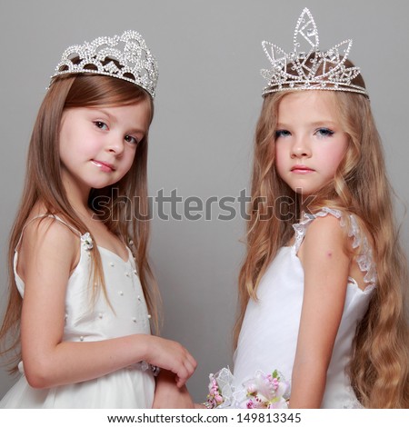 little girls in white dresses and a crown for the beauty contest