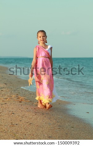 Girl in ancient style/Little goddess in a tunic on the beach