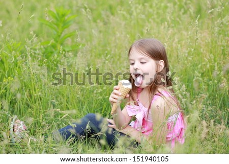 Cute young girl in casual clothes eat ice cream on the nature on Food and Drink