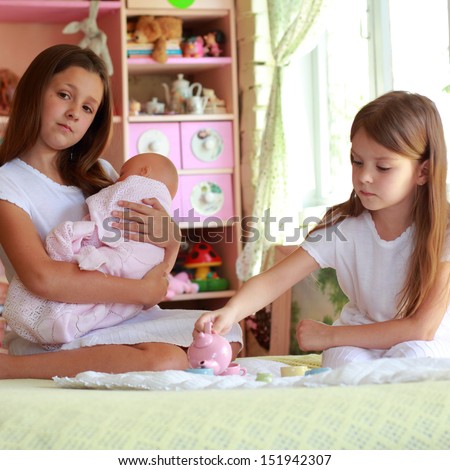 Little girls playing with her baby doll and pretending mom