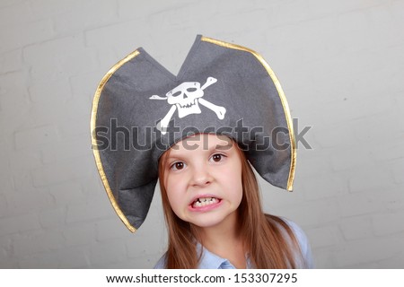 beautiful young girl in the role of an evil pirate terrible on gray background on Holiday
