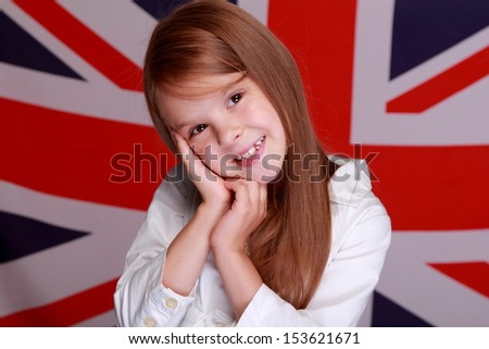Portrait of a young girl\'s sweet smile is on the background of the flag the UK
