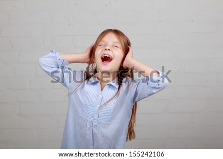 Angry little girl growls/Cute little girl put her hands to his ears and naughty