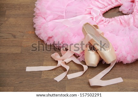 Children\'s ballet skirt and ballet shoes for the little ballerina on a background of wooden floor