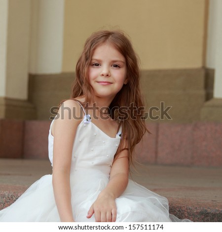 Little girls in white dresses with long hair outdoors