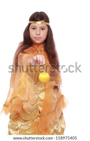 Cute cheerful little girl with long dark hair in a fairy dress is holding a Christmas ball on a white background