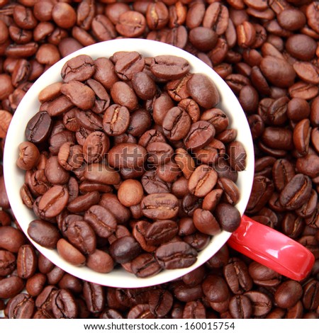 Top view on coffee beans in ceramic red coffee cup