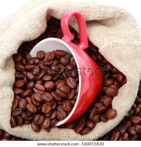 coffee beans in ceramic red coffee cup with heart symbol over burlap beige sack isolated on Valentine Day