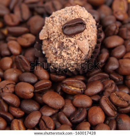 Chocolates with brazilian coffee beans over wooden background