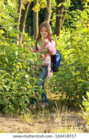 little girl with a school bag outdoor is happy to go to school