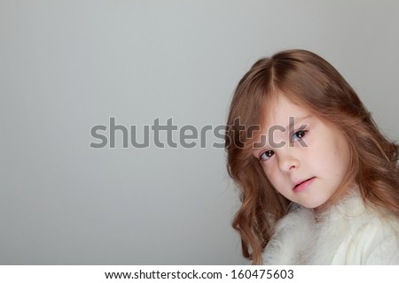 Caucasian little girl portrait sad  on grey background