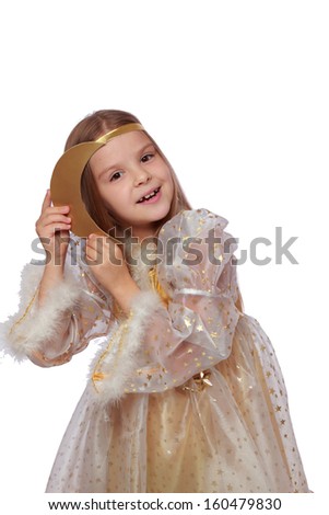 Charming smiling young child with an angelic smile in a beautiful fancy dress holding a golden moon on a white background on Holiday