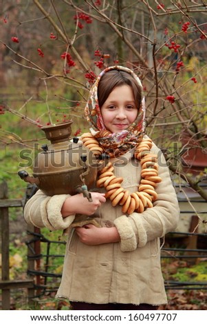 beautiful little girl in russian village traditional kerchief with round cracknel/traditional russian little girl with samovar at autumn outdoor
