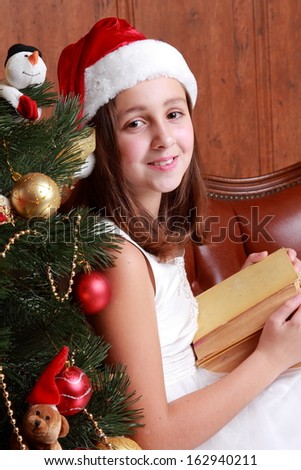 little miss santa sitting over the christmas tree and reading vintage big book