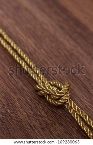 golden rope with a knot/Old wood with rope knot background