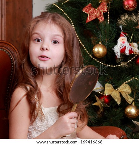 Picture of beautiful little princess girl with a mirror on Christmas time on Holiday theme
