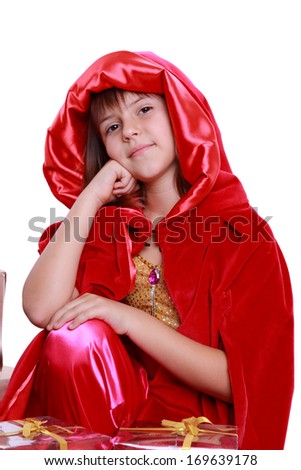 Portrait of a young attractive little girl dressed as Little Red Riding Hood wearing a red cape/Cute little girl wearing red cape