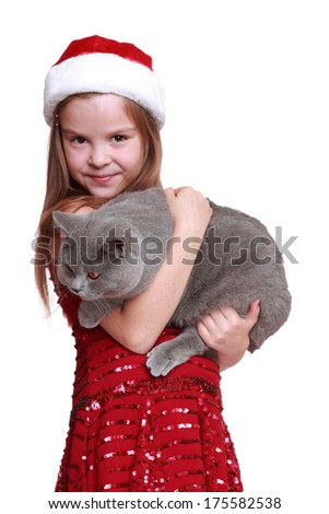 The best christmas present ever - happy little girl with her new cat isolated on Holiday theme/little santa hat holding cat on holiday theme