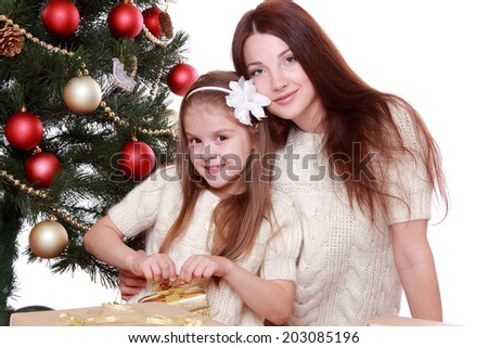 Smiling young mother and lovely little girl having fun time on Christmas time/Happy mother and daughter on Holiday theme