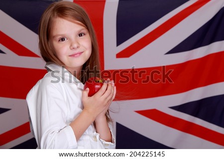 Image of a young English lady sweet smile holding a red apple on the background of the flag of Great Britain
