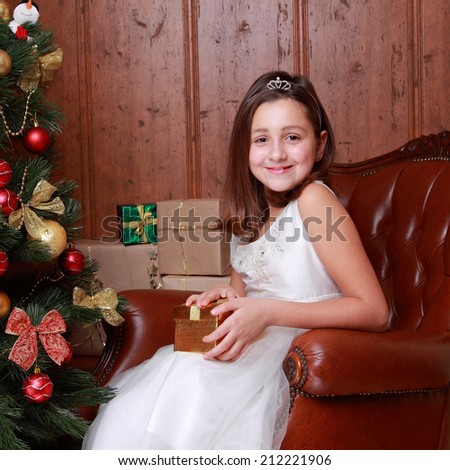 Happy smiley little girl over christmas decoration on Holiday theme/Happy little girl with Christmas gifts