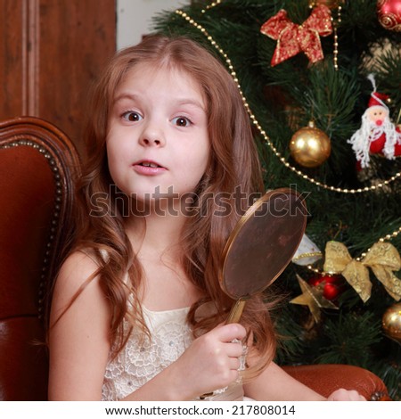 Picture of beautiful little princess girl with a mirror on Christmas time on Holiday theme