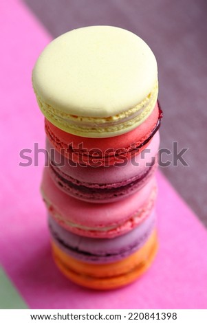 Tasty multicolored macaroon on a light pink background
