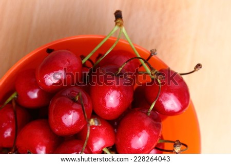 Delicious ripe cherries in the orange bowl
