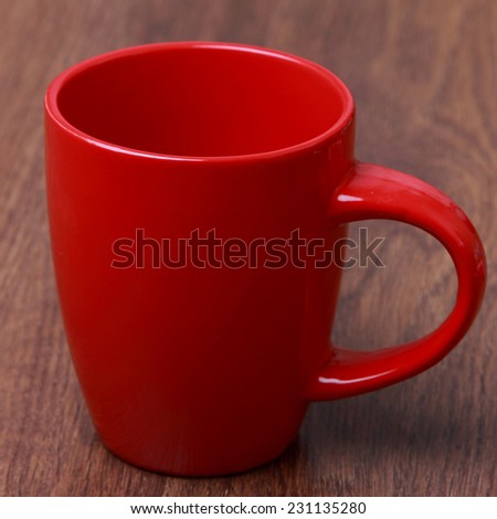 red cup over wooden background/red mug on wooden table