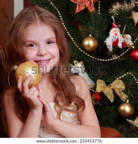 Beautiful young princess holding decorative golden ball for christmas tree on Holiday theme/Gorgeous little lady on Christmas