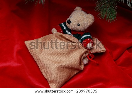Lovely teddy bear over golden sac over red velvet on Holiday theme
