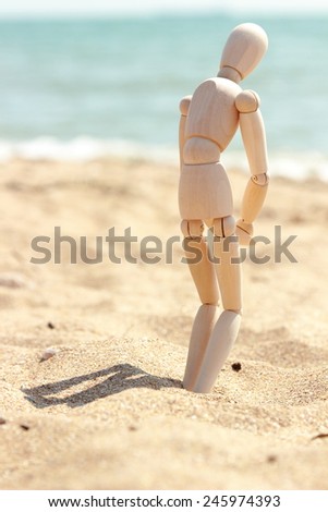 Wooden figure of  man over sand background/sea sand background Crimea, Russia