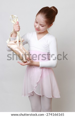 little ballerina holding ballerina shoes (pointe)