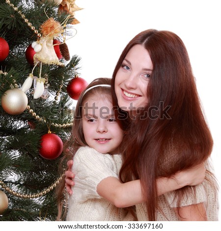 Smiling young mother and lovely little girl having fun time on Christmas time/Happy mother and daughter on Holiday theme