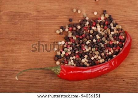 agriculture objects (red hot chilli and some ground peppers) over brown wooden background/hot chilli