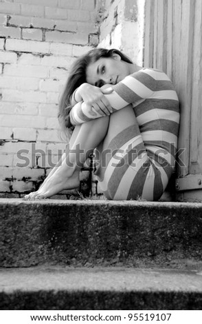 young sad urban girl sitting on the stairs in the street/sad girl