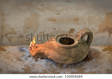 Ancient Middle Eastern oil lamp on grunge table