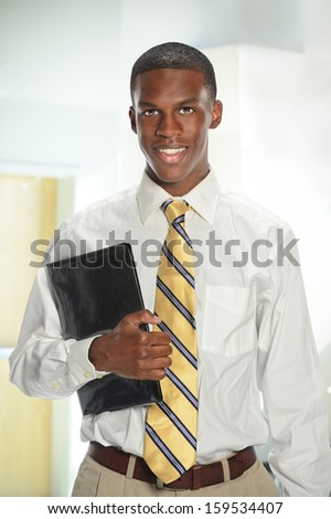 Portrait of African American businessman holding folder inside office building