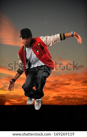 African American hip hop dancer jumping with sunset background